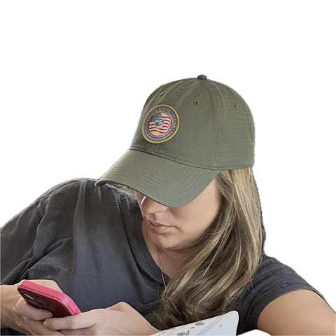 Woman with a Patriotic Pies hat on using her phone